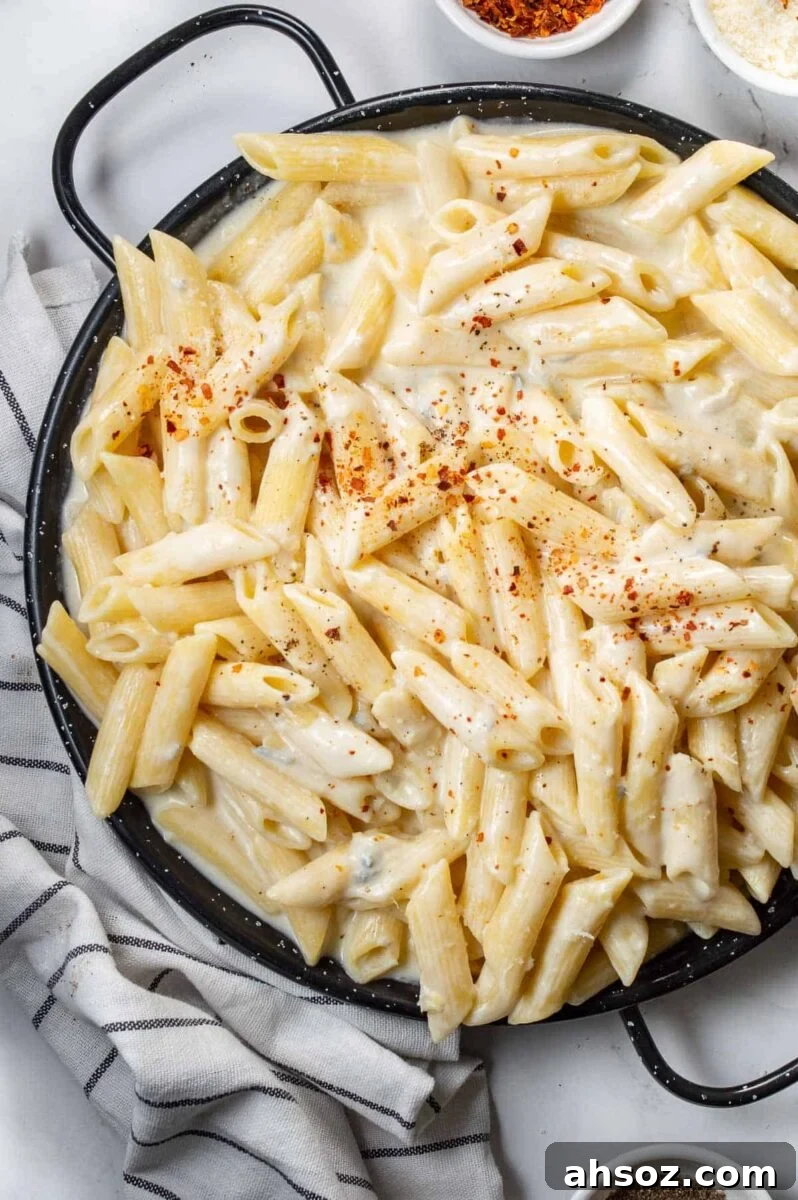 A black pan with pasta in a creamy sauce.