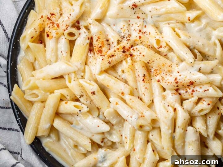 A black pan with pasta in a creamy sauce.