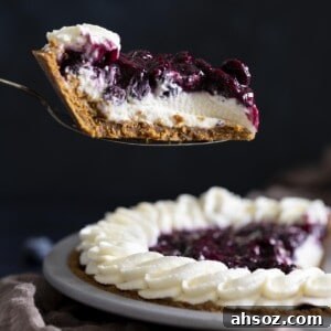 A slice of blueberry cream cheese pie is lifted up with a pie server.