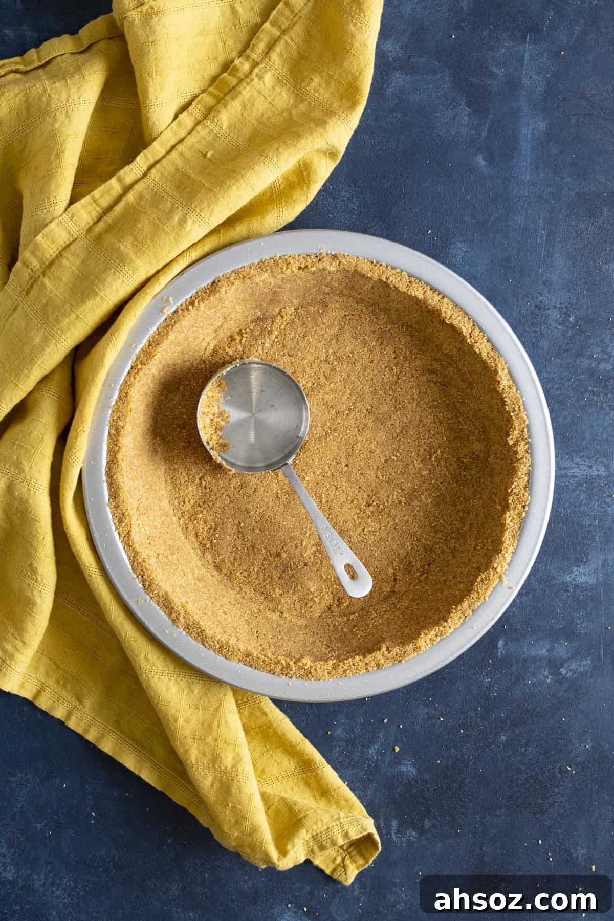 A Graham cracker crust with a measuring cup inside it.