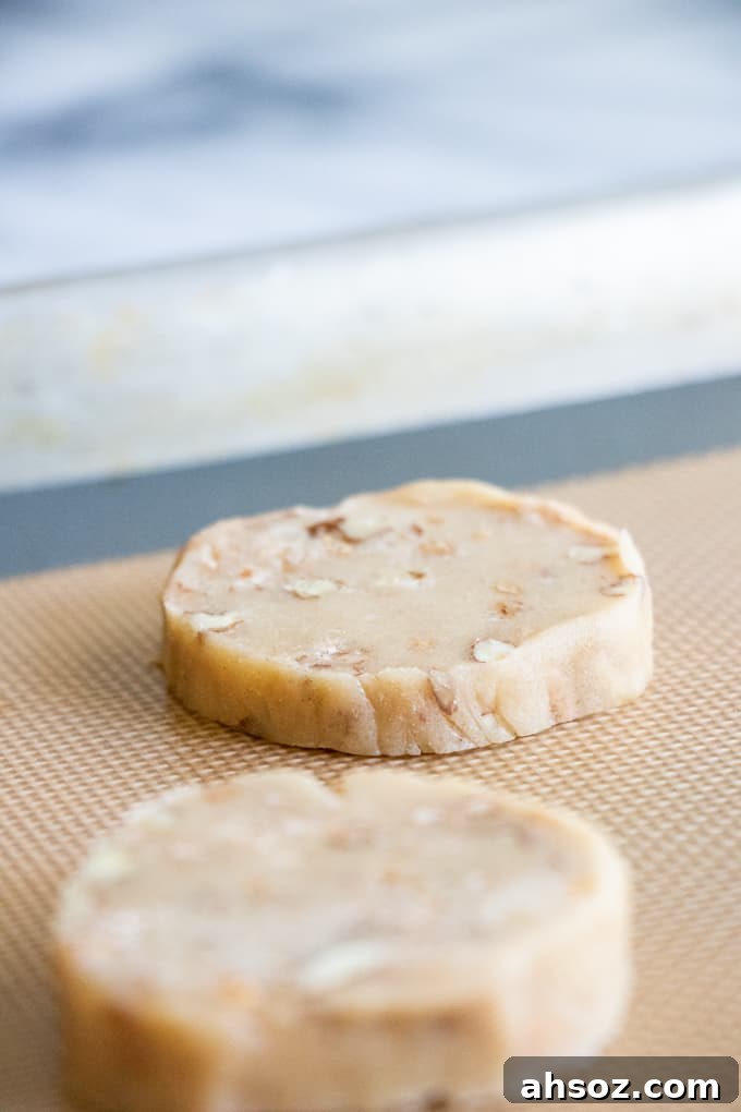 Butter Pecan Shortbread cookie dough formed into rounds and placed on a baking sheet.