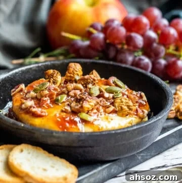 Brie in small cast iron skillet with grapes in the background.
