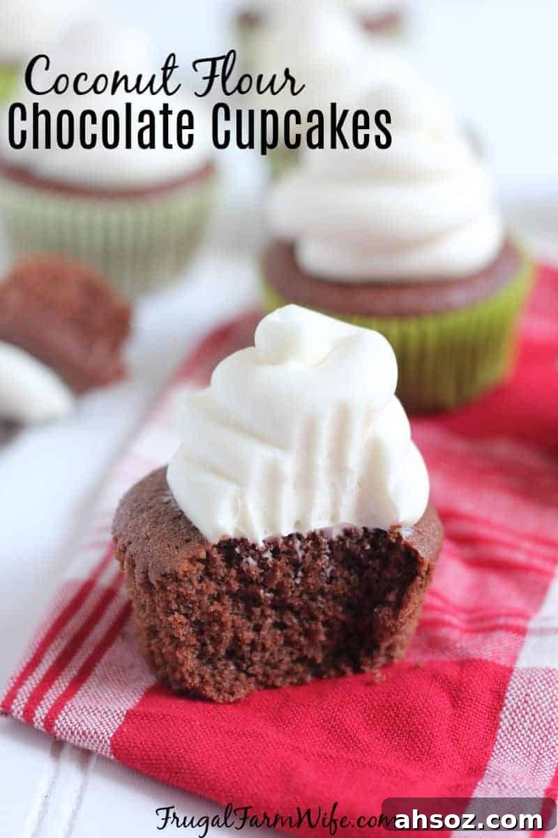 Chocolate cupcakes on a red and white napkin, with one cupcake in front showing a bite and white frosting swirled on top.