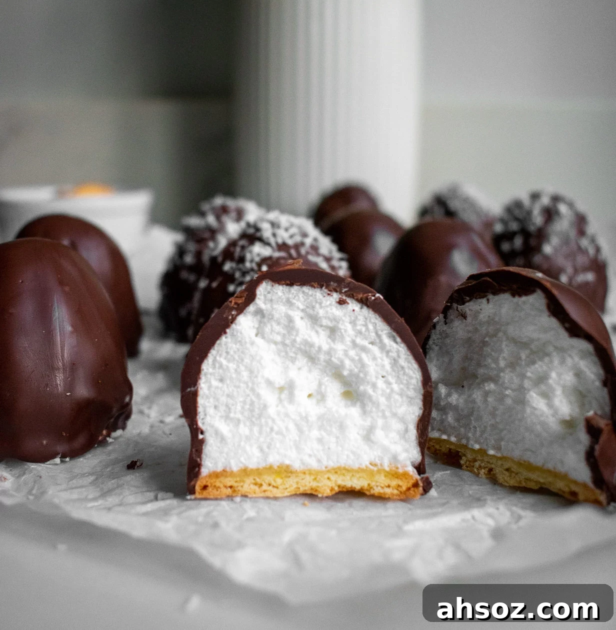 Meringue domes with a vanilla cookie base covered with chocolate and coconut shreds.