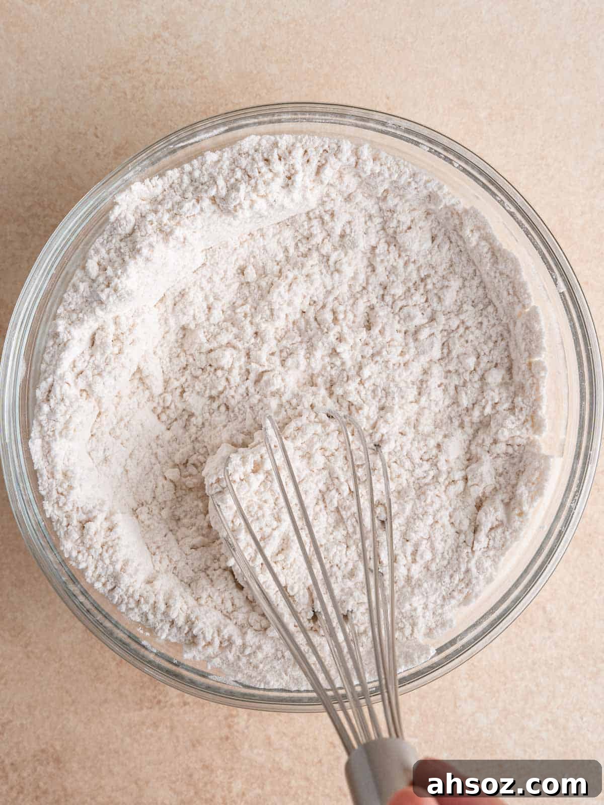 Whisking dry cake ingredients in a bowl.