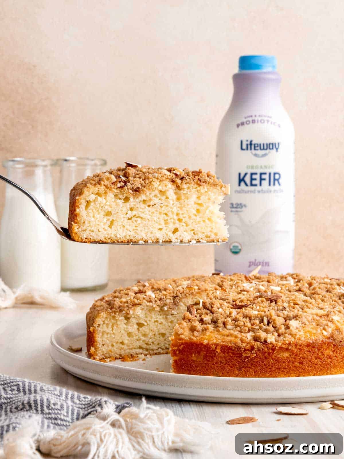 Lifting a slice of almond coffee cake with a cake server.