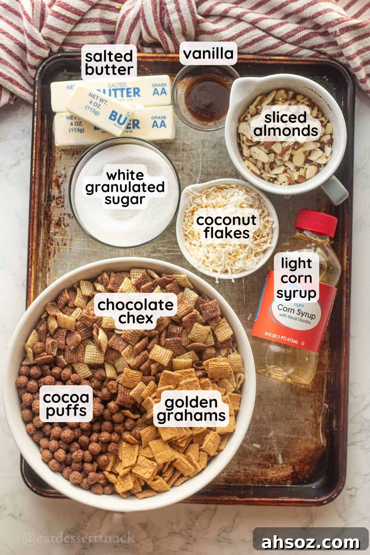 Labeled ingredients for chocolate chex mix on metal pan.