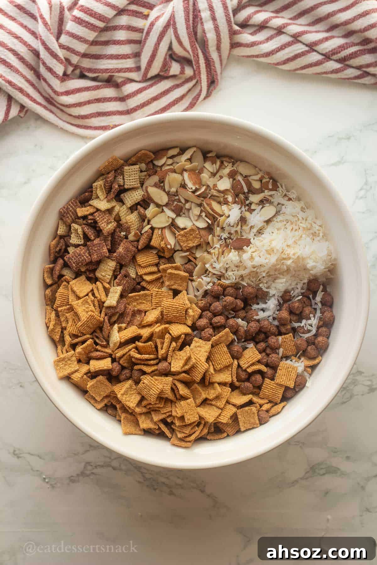 Almonds, chex, cocoa puffs, coconut, and golden grahams in bowl.