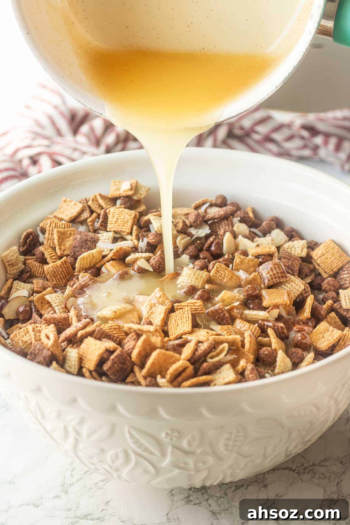Pouring hot corn syrup mixture into bowl of cereal.