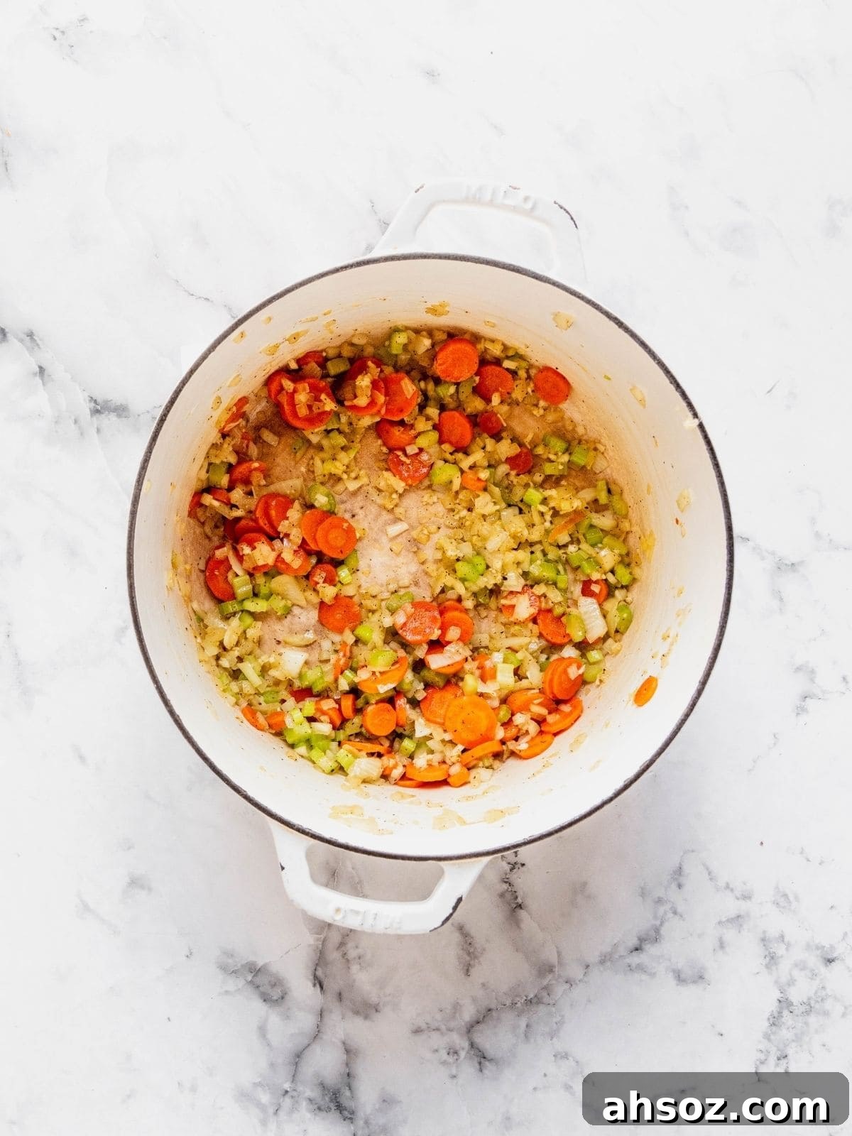Recipe step showing the sautéing of the celery, carrots, onion and garlic in a soup pot.