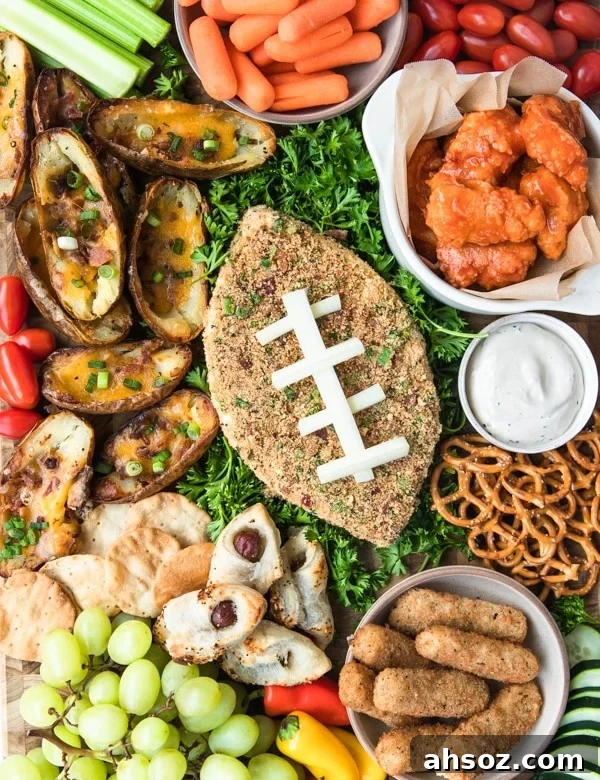 a jalapeno popper cheese ball on a cutting board with game day snack foods