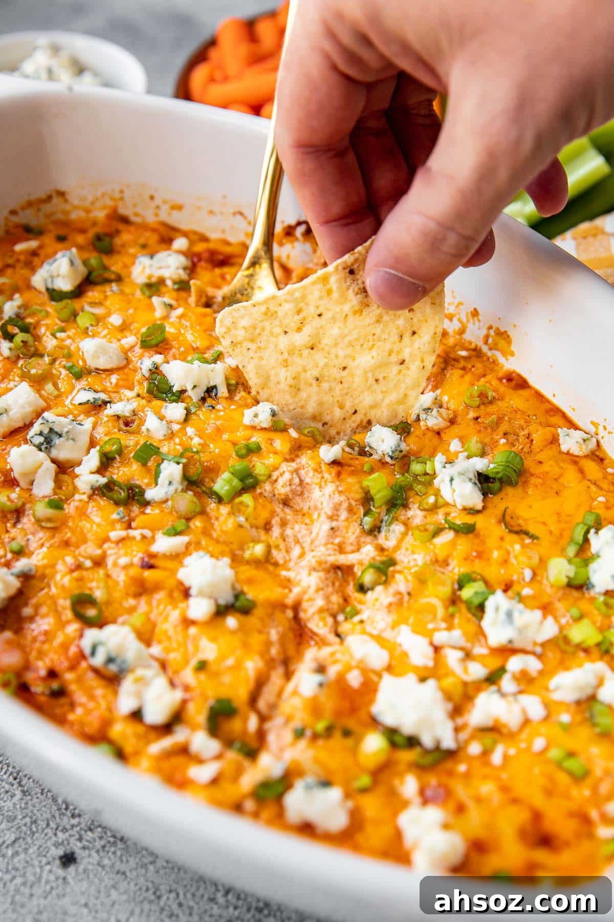a chip dunking into a buffalo chicken dip. 