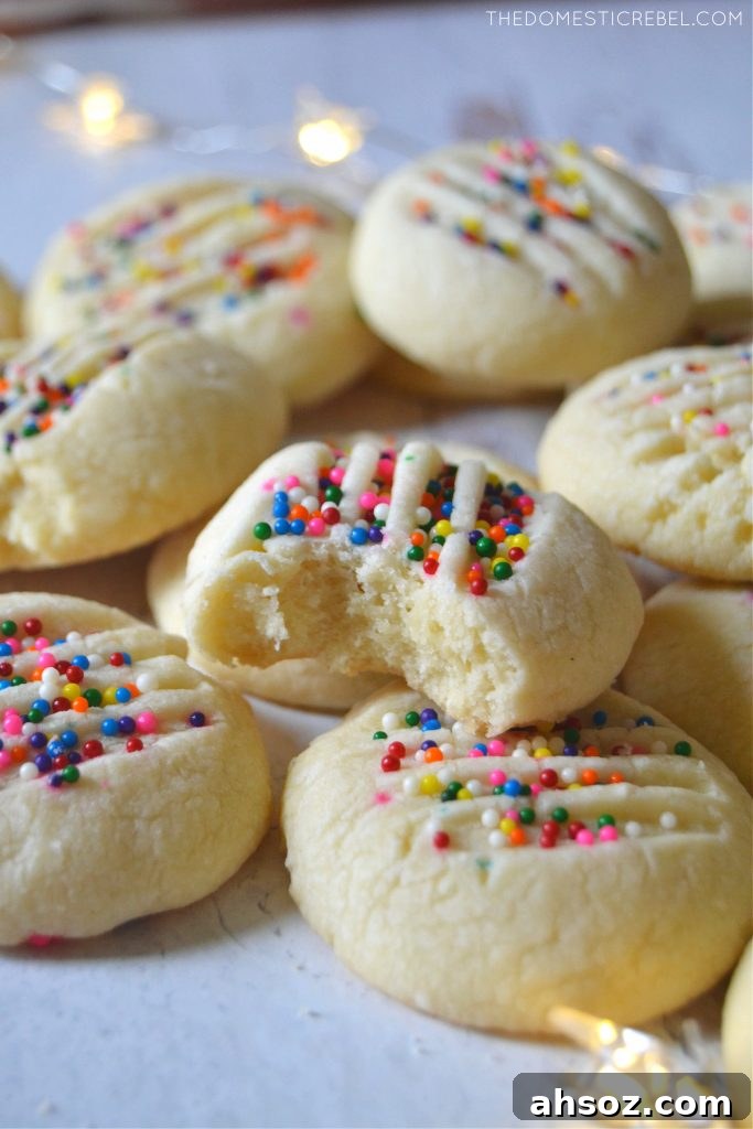 Buttery Whipped Shortbread Cookies That Melt in Your Mouth 6 Arrangement of shortbread cookies on a white plate, one with a bite missing