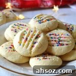 a white plate filled with whipped shortbread cookies
