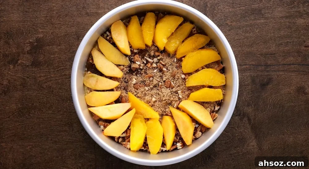 Peach slices added to cake pan.