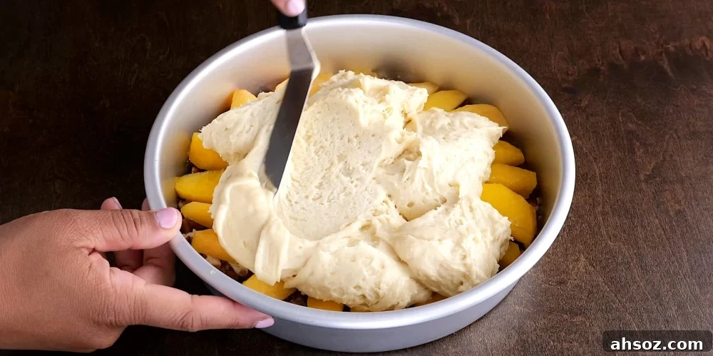 Spreading batter over peaches.