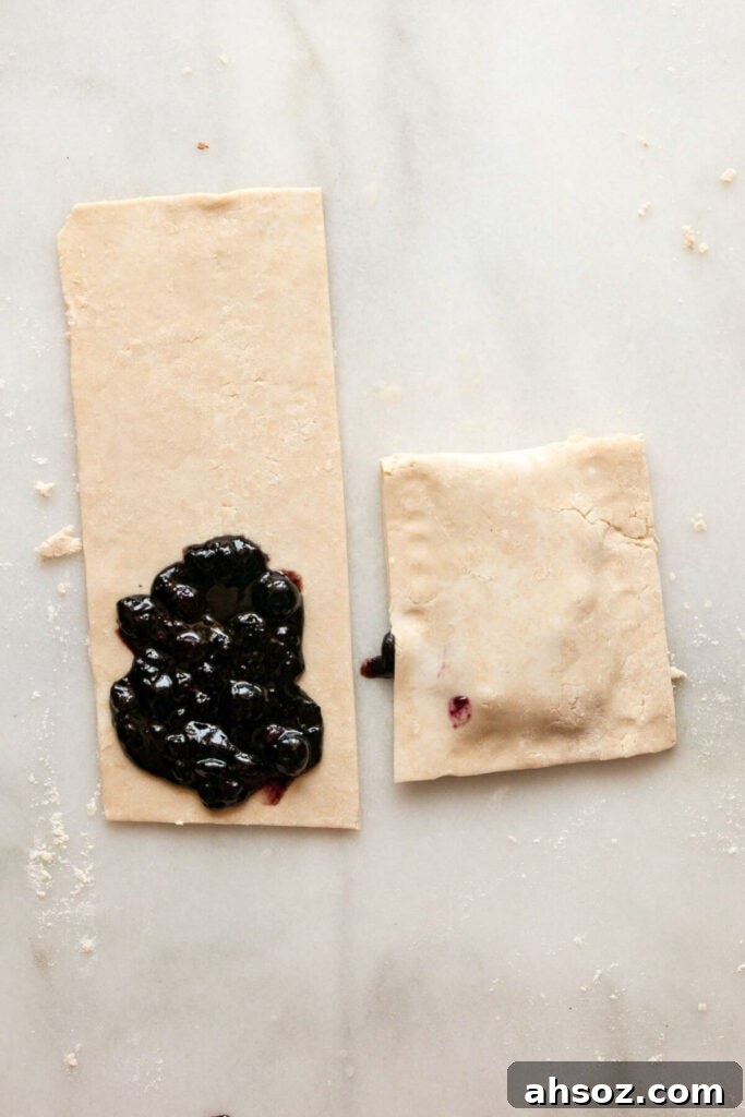 adding homemade blueberry jam to pop tarts