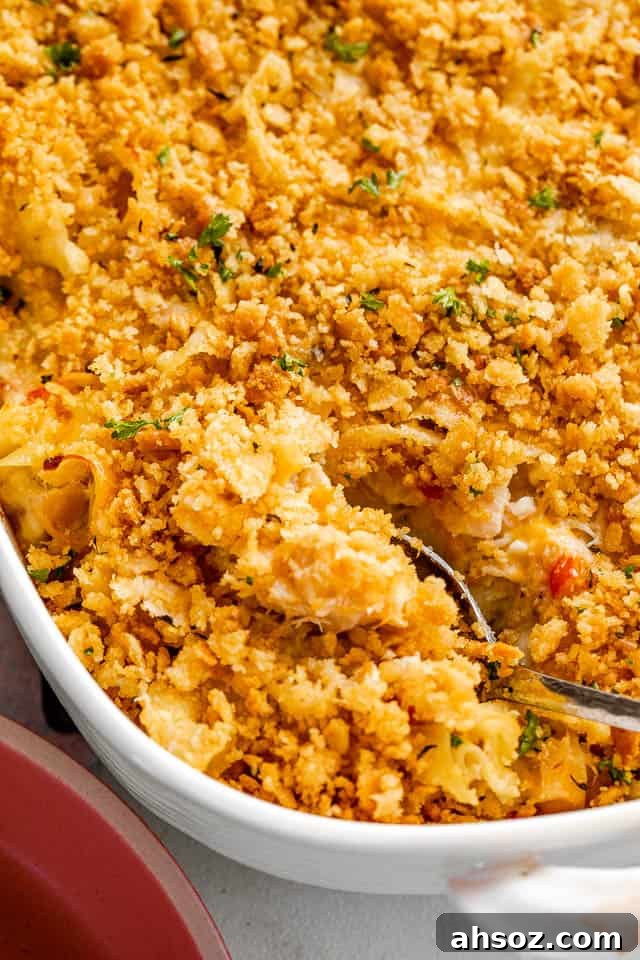 silver spoon cutting into a tuna noodle casserole topped with ritz crackers