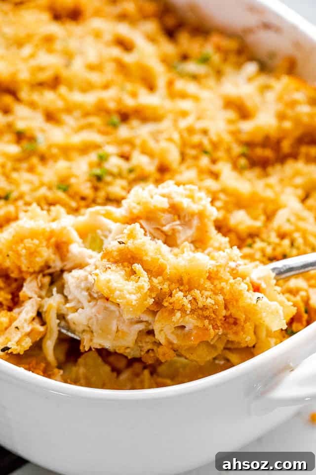 scooping out tuna noodle casserole from baking dish