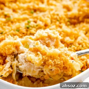 scooping out tuna noodle casserole from baking dish
