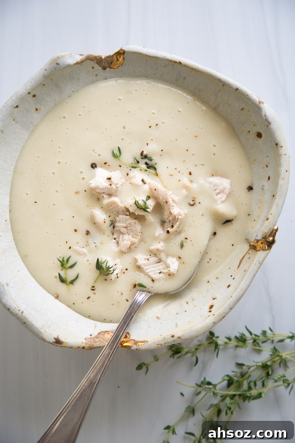 Bowl of gluten-free cream of chicken soup with thyme sprigs