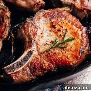 seared pork chops in a cast iron pan.