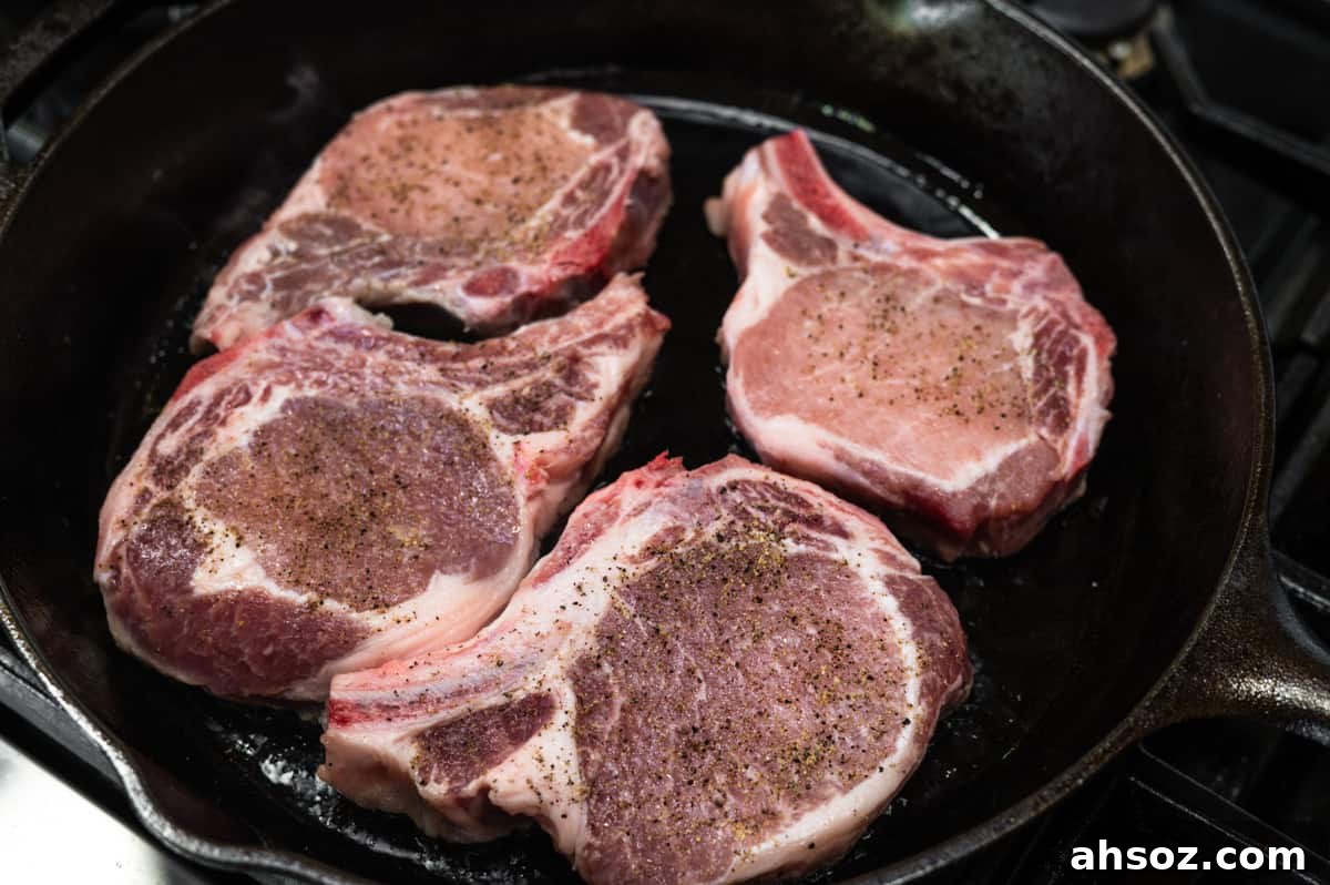 bone in pork chops in cast iron pan.