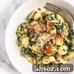 Creamy kale gnocchi with bacon and onions.