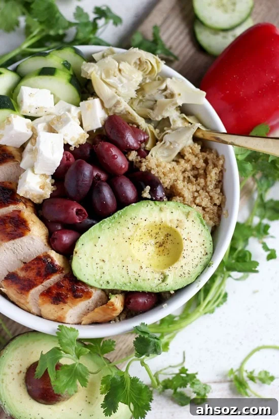A fully assembled chicken quinoa bowl in a white bowl.