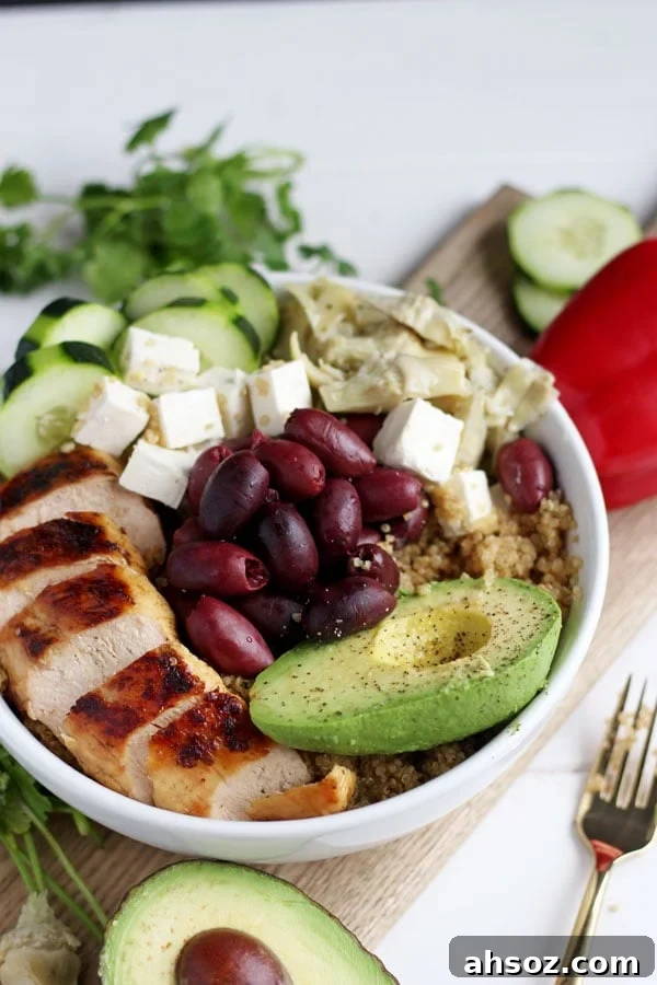 Bowl of quinoa, chicken, feta cheese, olives, cucumber and avocado.