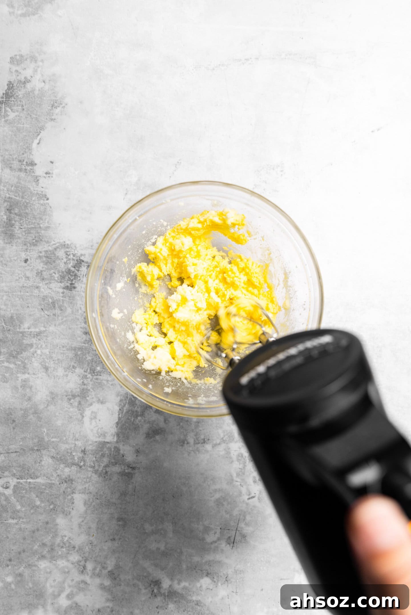 Egg and vanilla being beaten into butter and sugar mixture.
