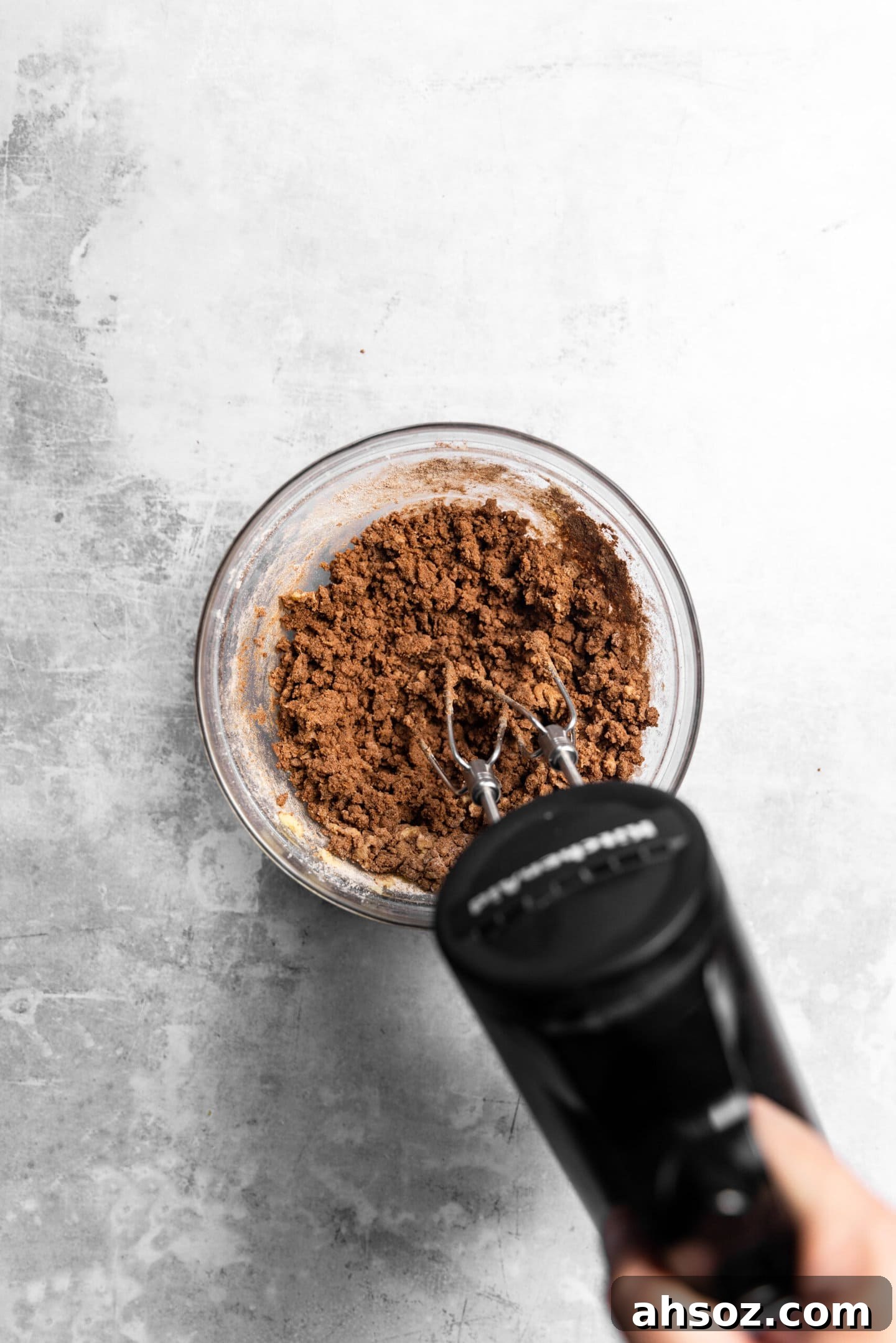 Dry ingredients being beaten into the wet to form chocolate sugar cookie dough