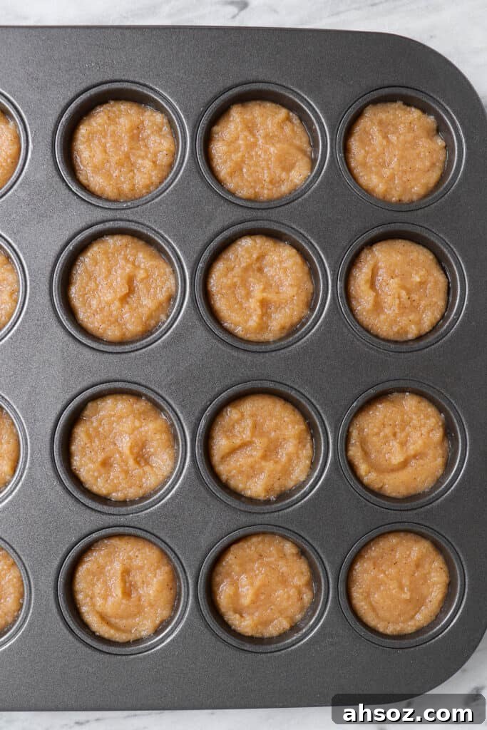 Unbaked apple donut hole batter in a mini muffin pan
