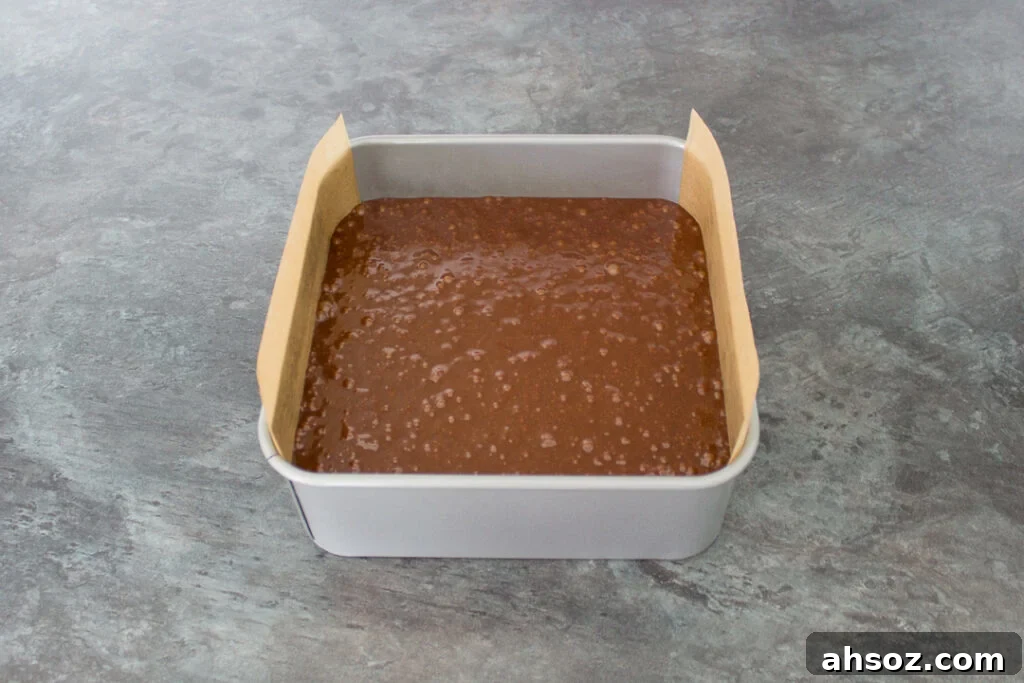 Unbaked ultimate chocolate brownie batter in a lined baking tin.
