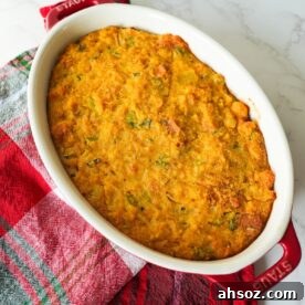 Golden brown cornbread dressing in a small baking dish with a soft center and crisp, buttery edges.