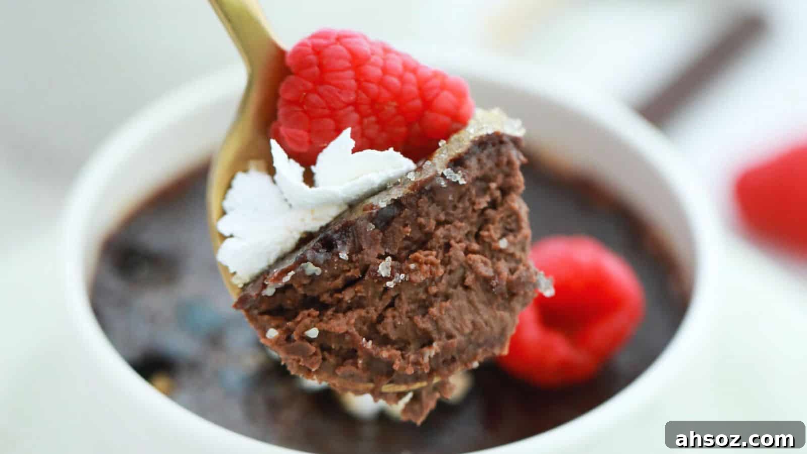 Three cups of chocolate pudding with whipped cream and raspberries.