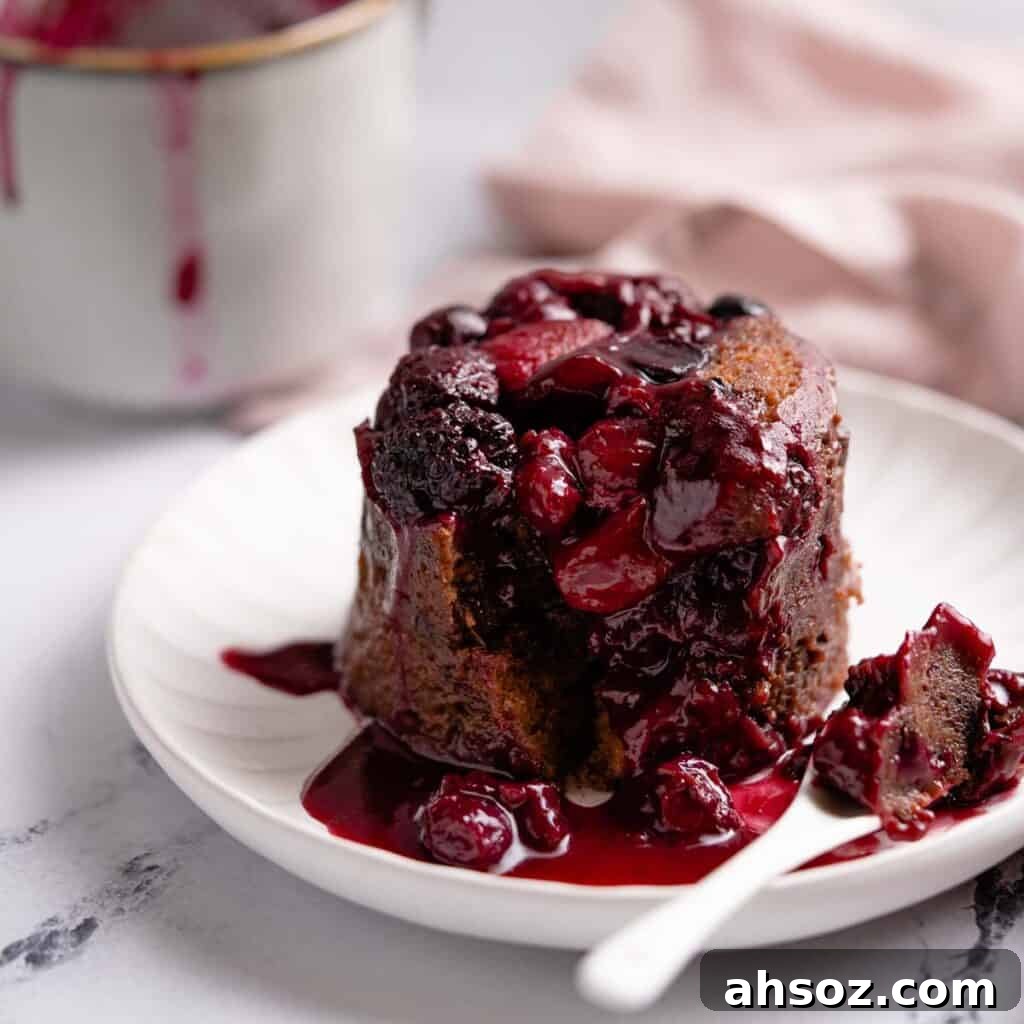 chocolate berry mug cake on plate with spoon on the side