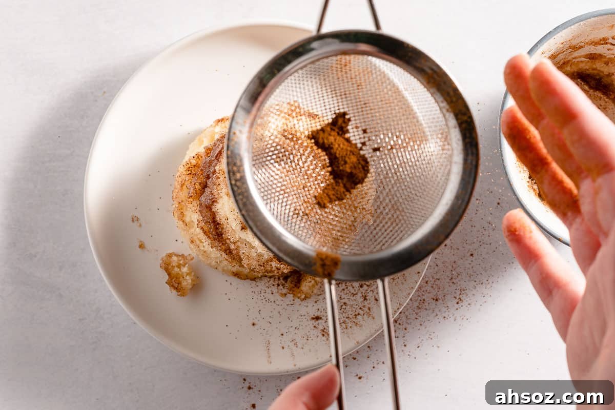 cinnamon being dusted overtop snickerdoodle mug cake