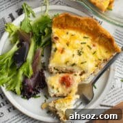 This is a square picture of tomato bacon goat cheese quiche with gruyere.