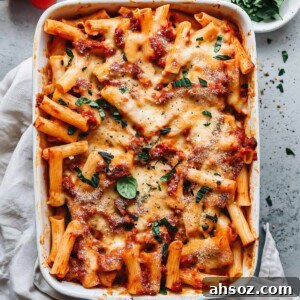 Easy baked ziti with sausage and basil in a baking dish.
