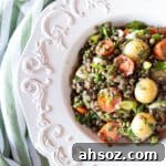 Potato and lentil salad with tomatoes, scallions, and oregano in a white bowl.