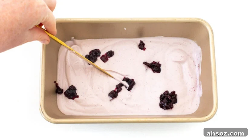 Blueberry jam swirled into cottage cheese ice cream in a loaf pan.