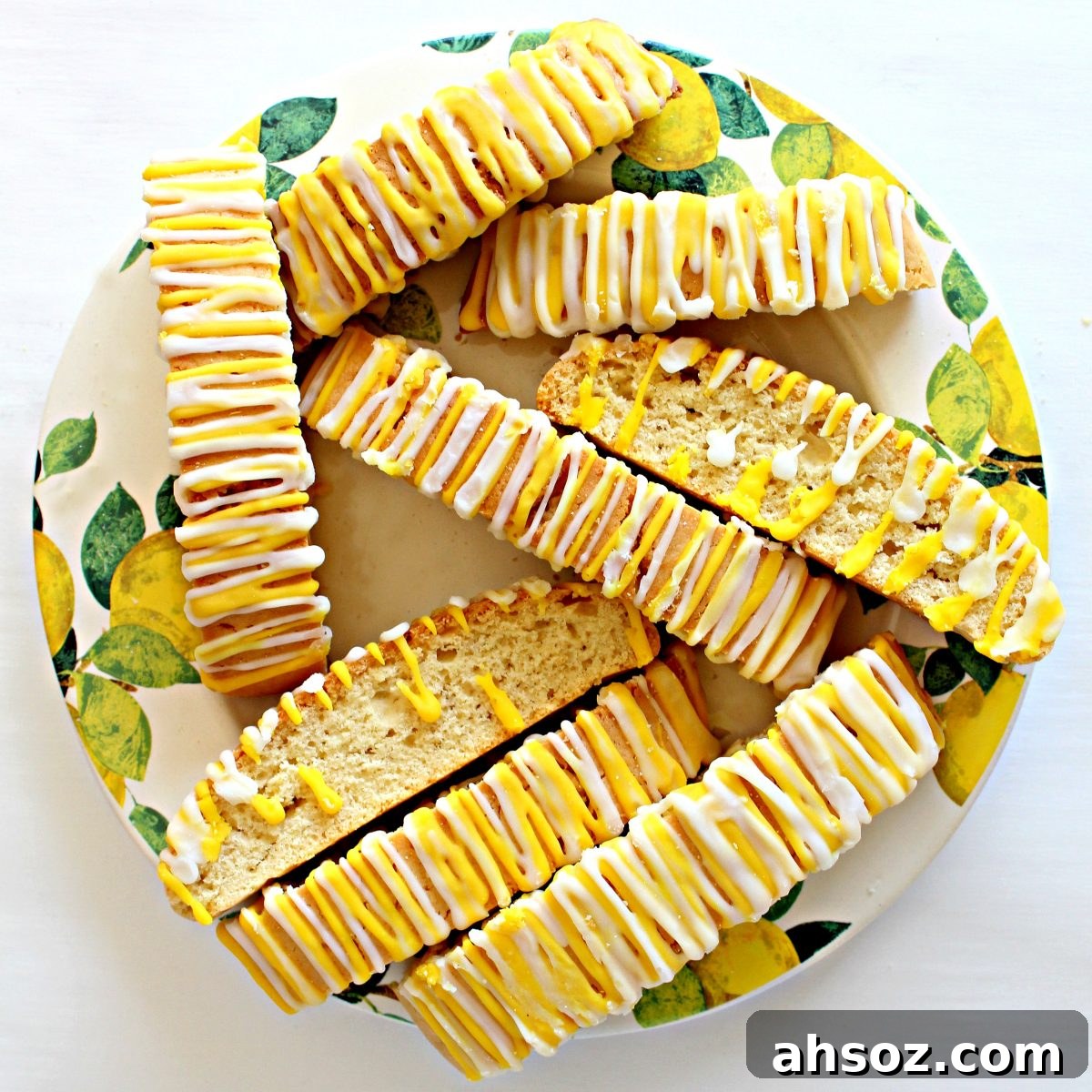 Serving plate of biscotti, showing zigzag icing stripes on top and others showing cut edge.
