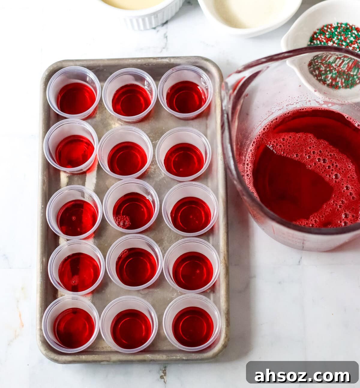 cherry jello in shot glasses on a baking tray
