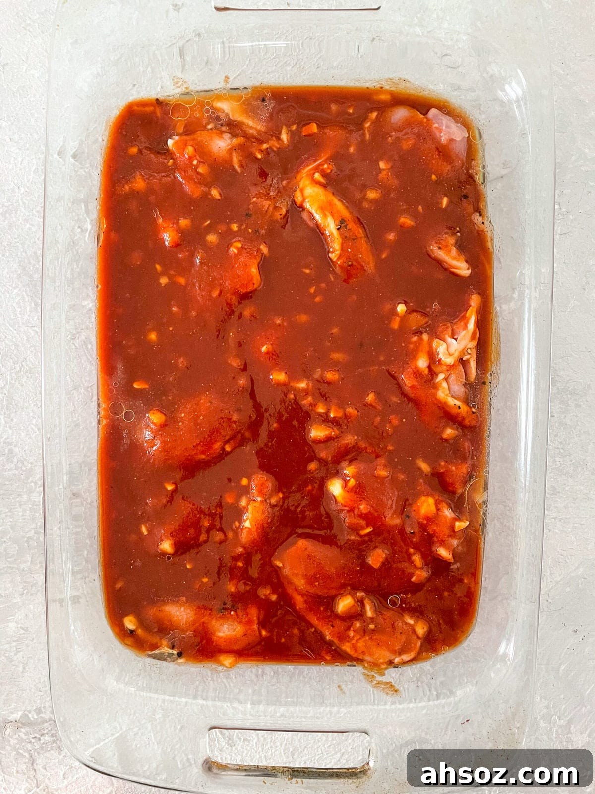 Chicken thighs in a baking dish with homemade barbecue sauce