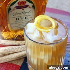 gold rush cocktail with bottle of whiskey in background