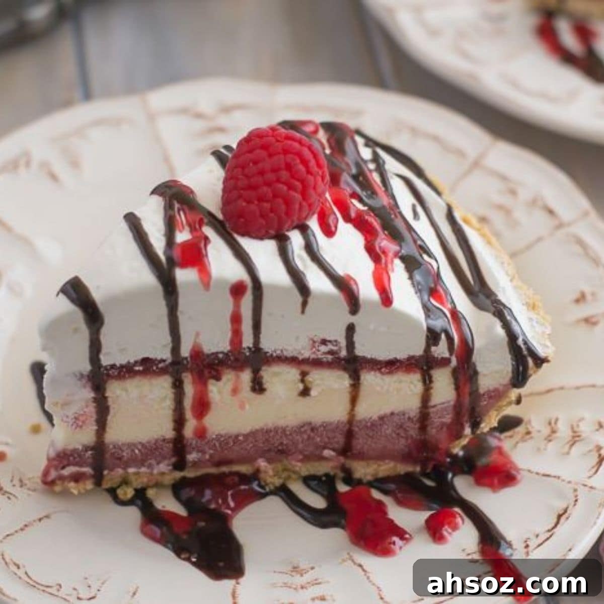A slice of raspberry cheesecake pudding pie on a dessert plate.