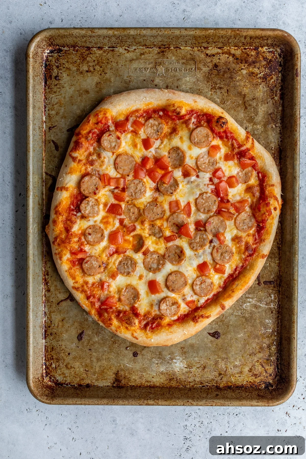 chicken sausage pizza on a baking sheet